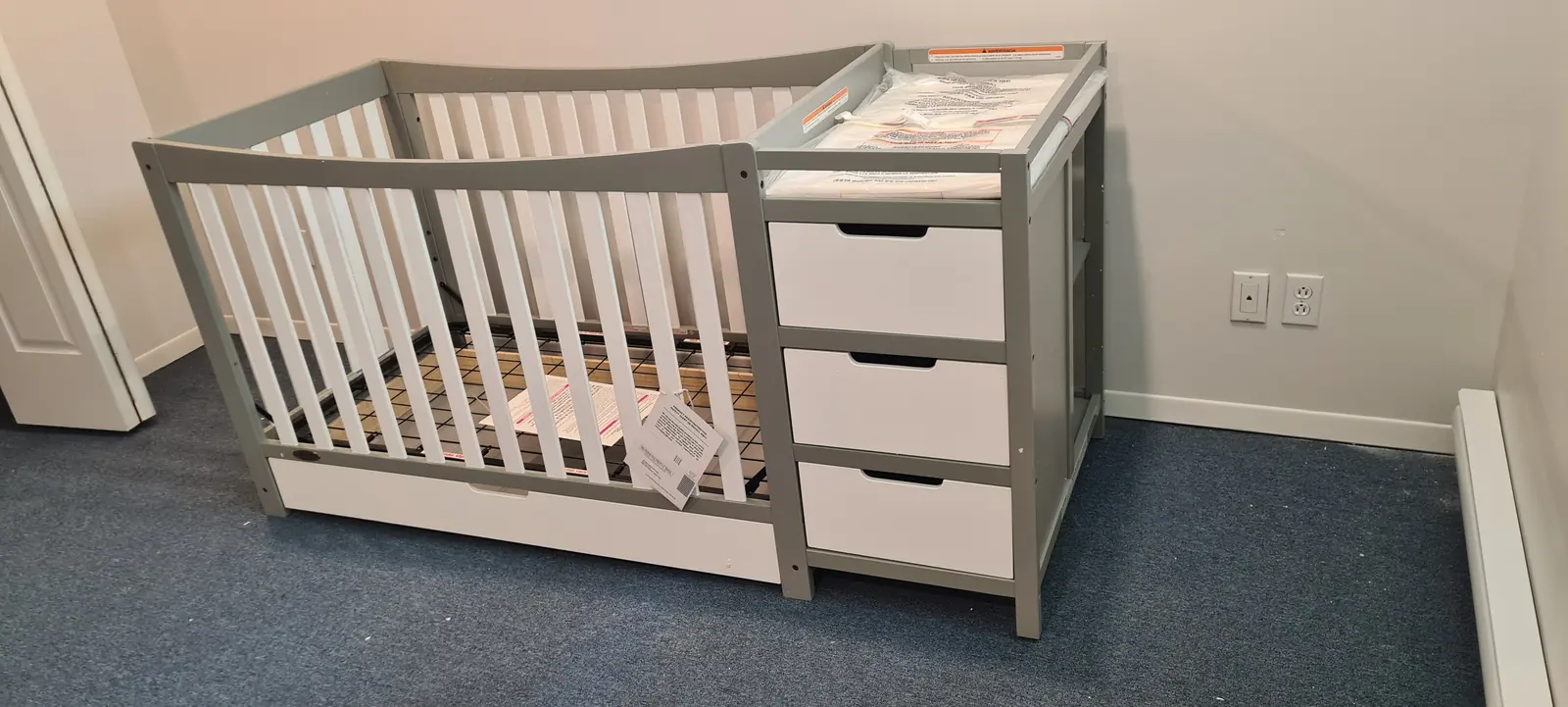 Lit de bébé blanc avec tiroirs de rangement intégrés sur le côté