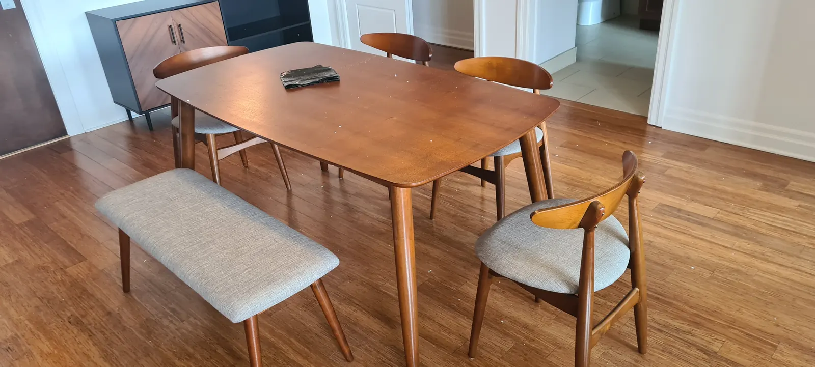 Table à manger en bois accompagnée d’un banc et de chaises