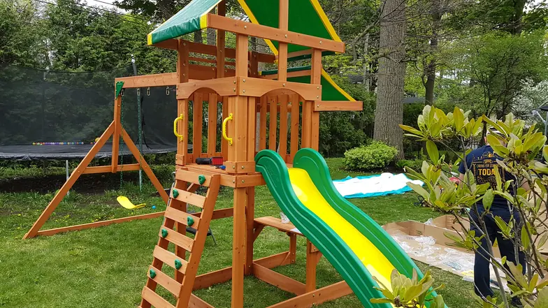 Module de jeux en bois avec glissoire verte et balançoires