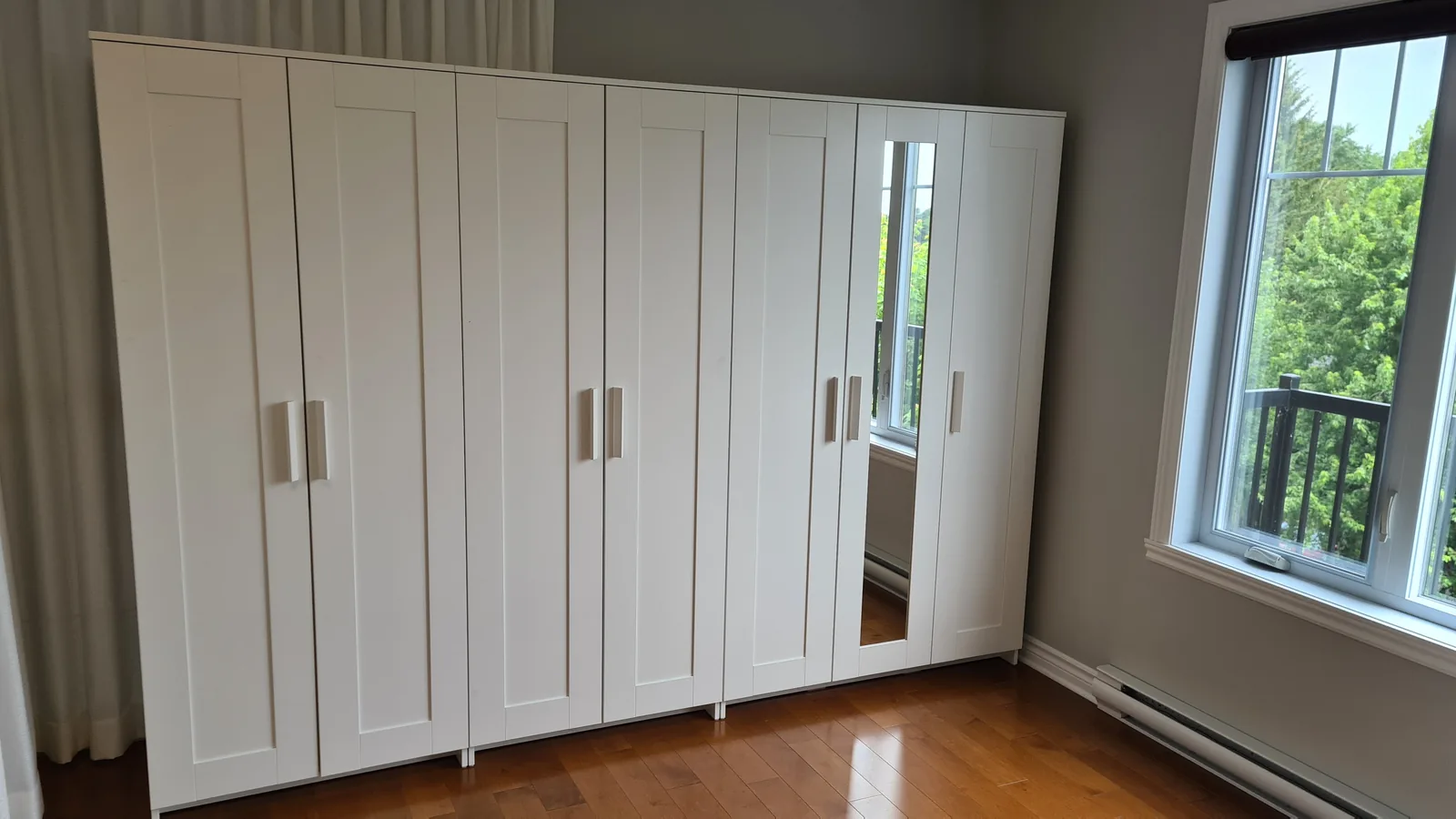 Garde-robe blanche avec portes battantes et miroir central